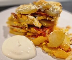 Simple Layered Potato Casserole on a Plate with Sour Cream