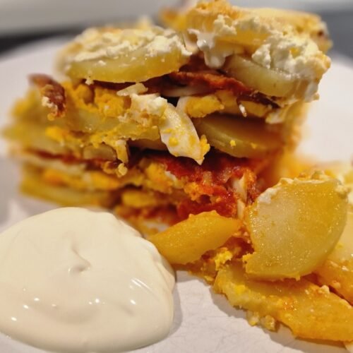Simple Layered Potato Casserole on a Plate with Sour Cream