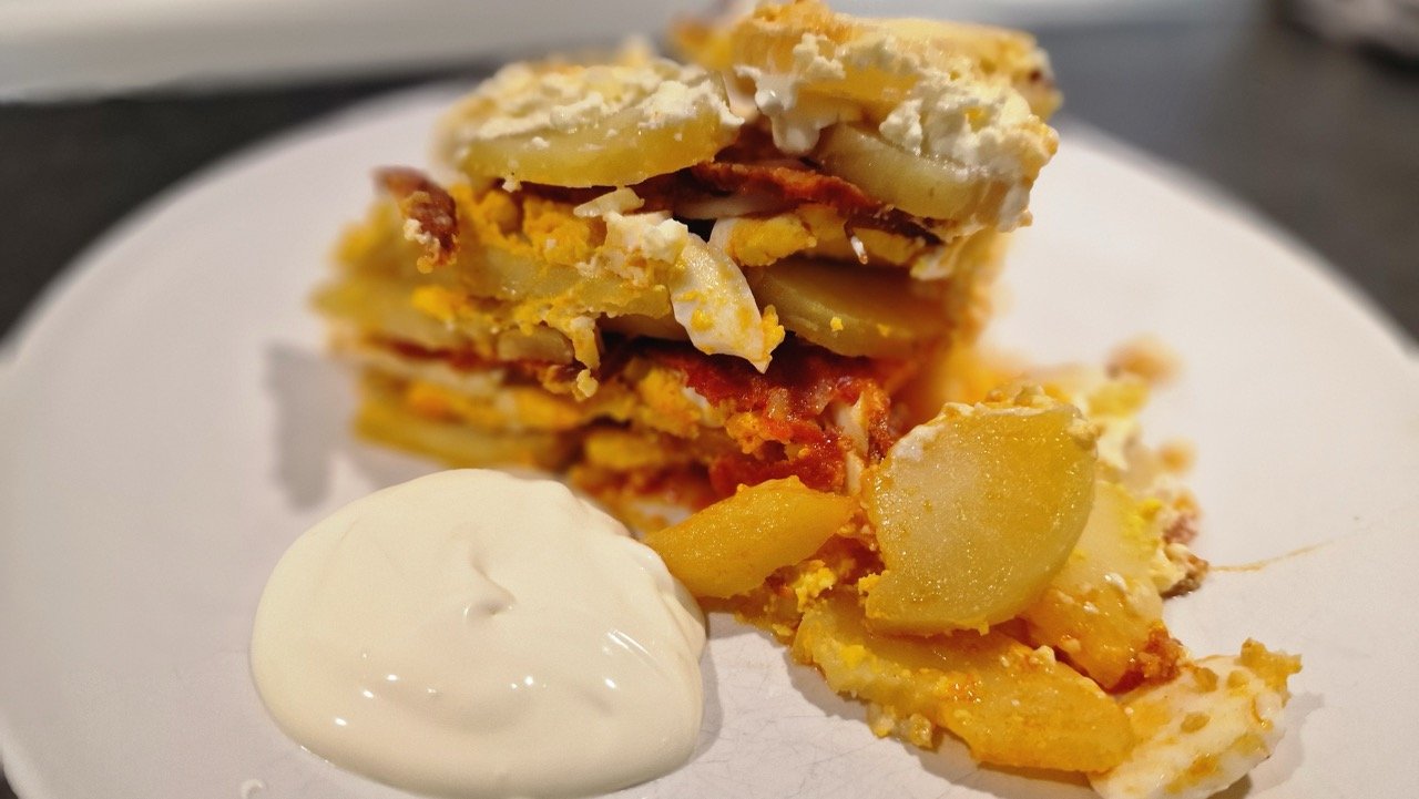 Simple Layered Potato Casserole on a Plate with Sour Cream