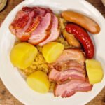Choucroute garnie served with sauerkraut, smoked meats, sausages, and potatoes