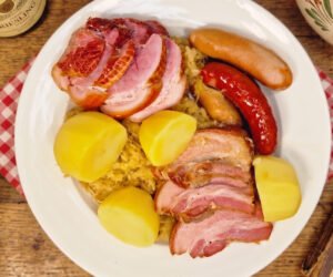 Choucroute garnie served with sauerkraut, smoked meats, sausages, and potatoes