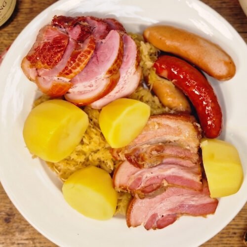 Choucroute garnie served with sauerkraut, smoked meats, sausages, and potatoes