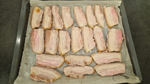 Pork belly slices after the first stage of roasting