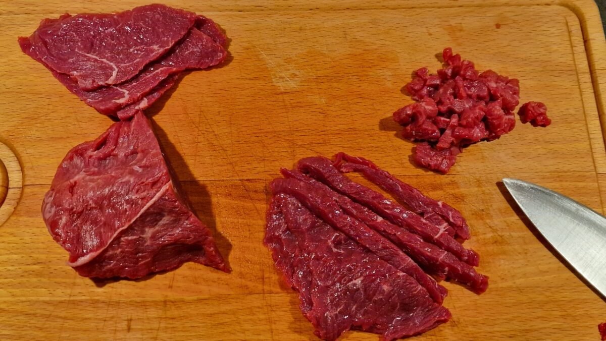 Beef being cut into small cubes for steak tartare