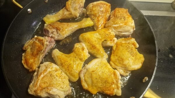 Chicken pieces browning in olive oil