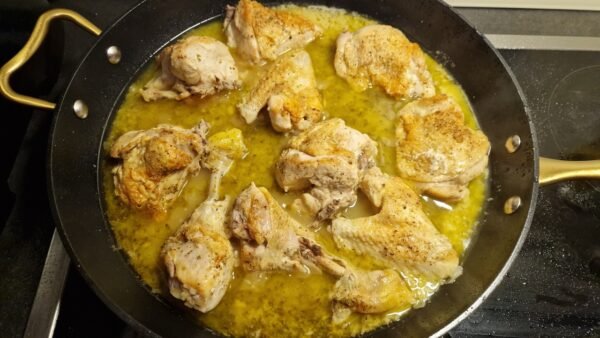 Lemon sauce thickening around the chicken