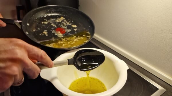 Spooning the olive oil into a separate container