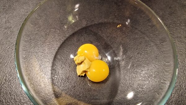 Dijon mustard and egg yolks in a bowl