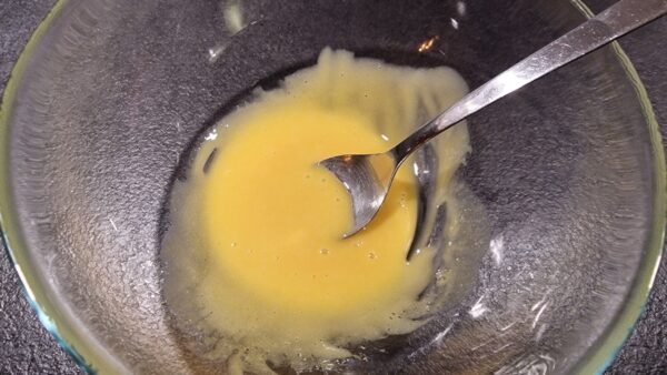 Oil being mixed into the mustard and egg yolks