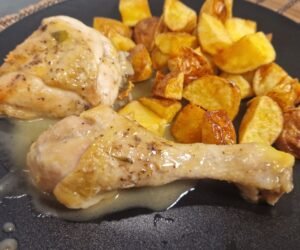 Pollo al ajillo with fried potatoes on a plate