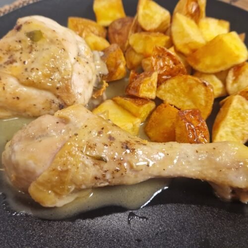 Pollo al ajillo with fried potatoes on a plate