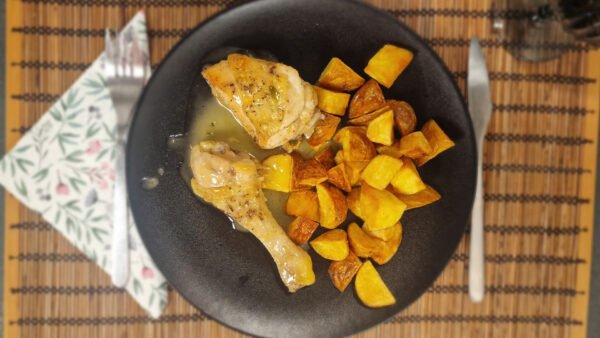 Pollo al ajillo and fried potatoes viewed from above