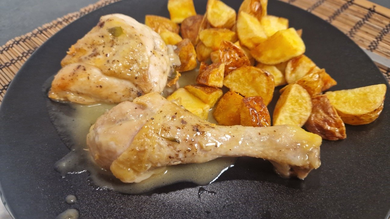Pollo al ajillo with fried potatoes on a plate