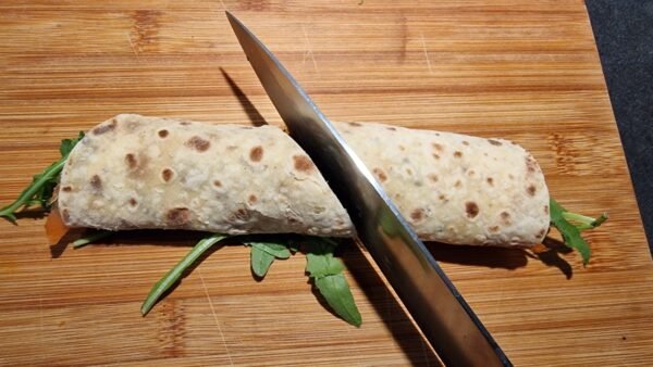 Cutting smoked salmon lompe rolls in half